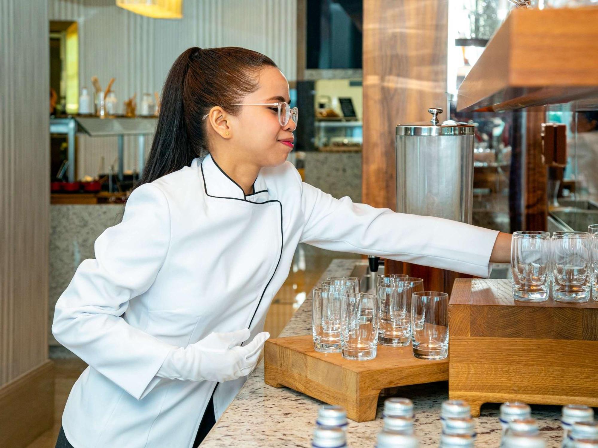 Moevenpick Hotel & Apartments Ghala Muskat Bagian luar foto A barista at work